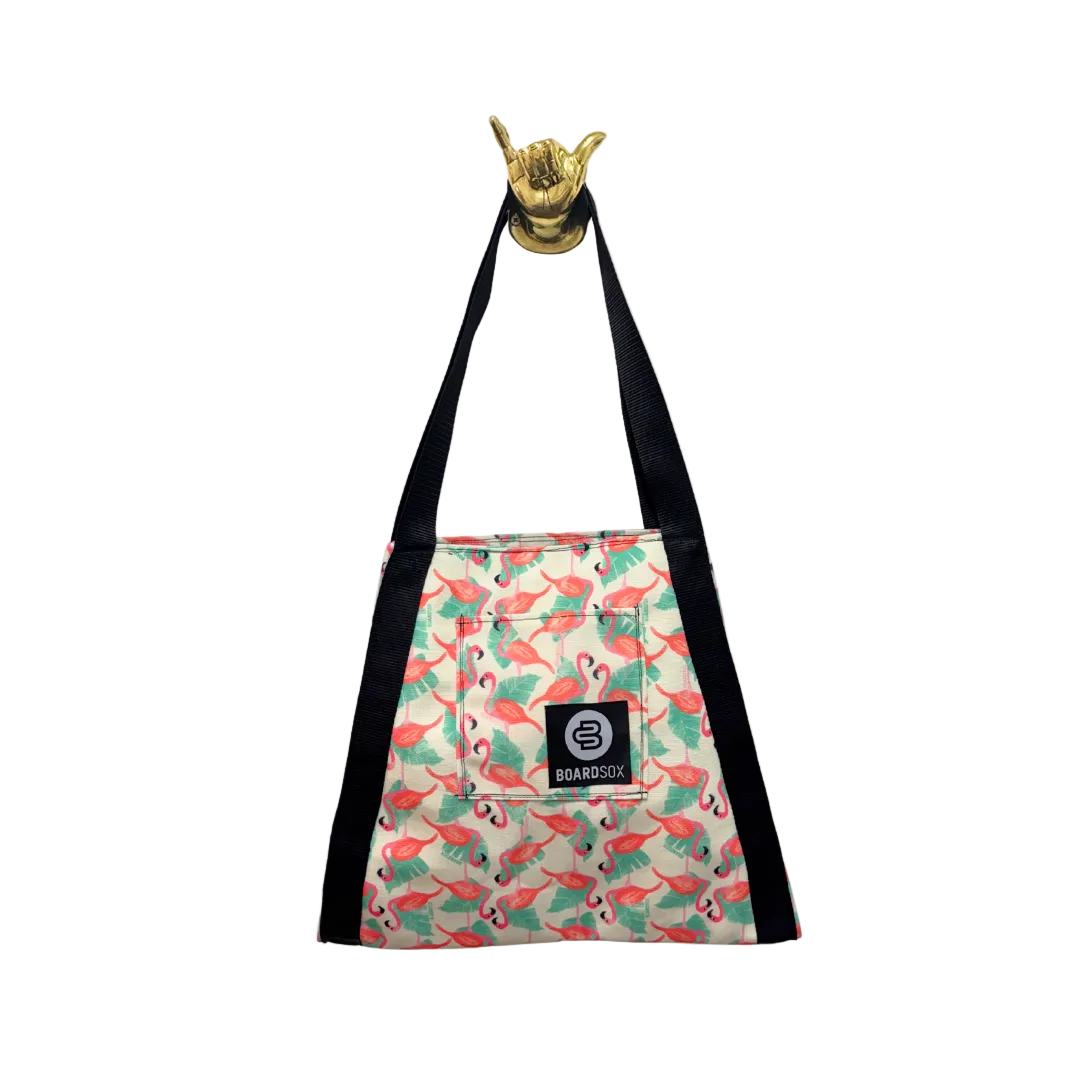 Flamingo-patterned bag with a black strap and gold hand sign on a white background